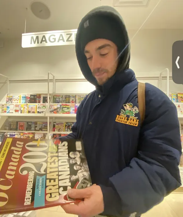 Michael reading a magazine at a newsstand