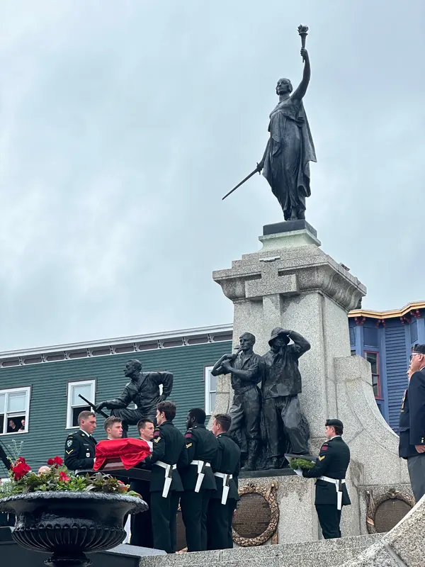 Uniformed members gather with the casket at the foot of the National War Memorial in St. John's